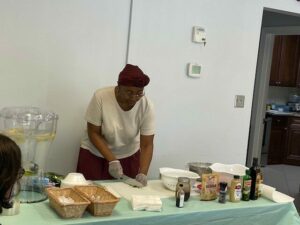 Extension Master Food Volunteer demonstrates preparing basil chiffonade