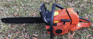 Orange chainsaw set on grass